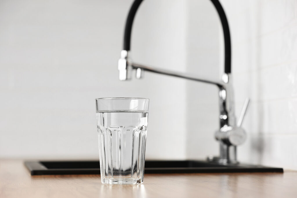 photo of a tap and glass of water