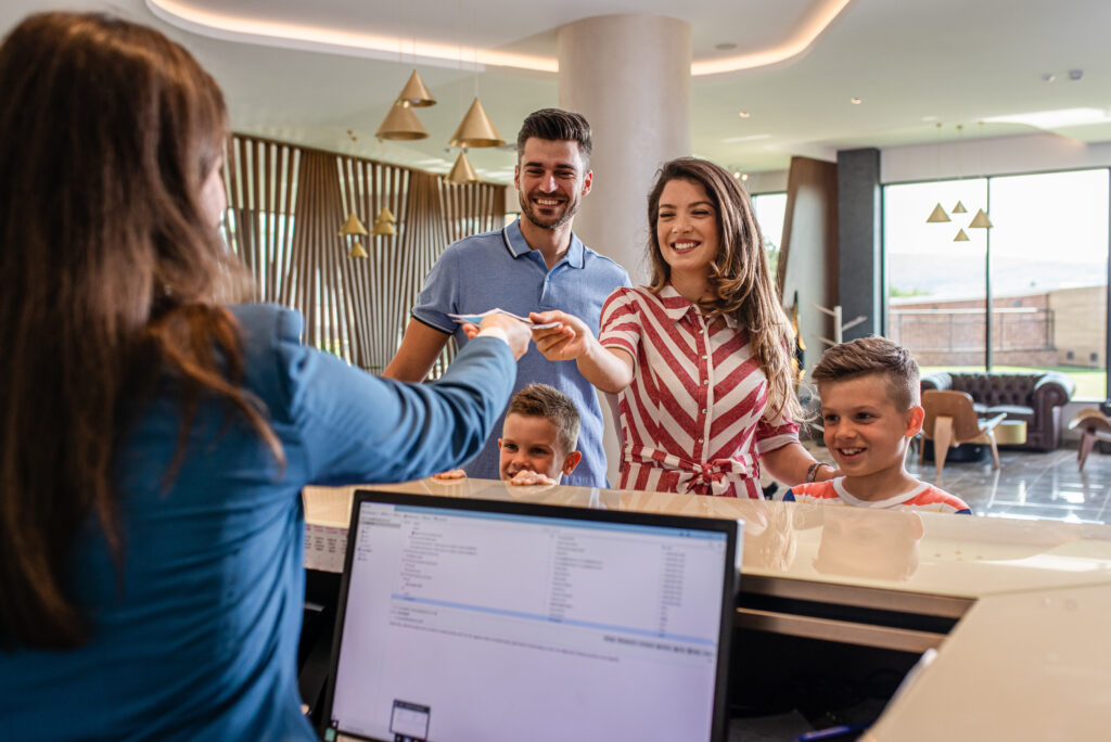 a family of guests checking in at a hotel