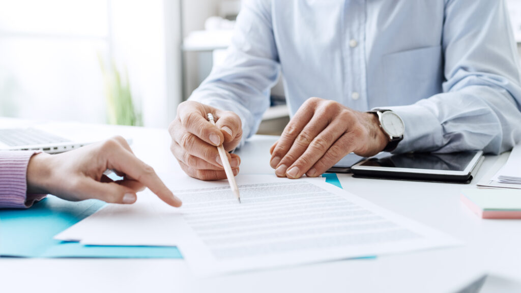 two people at a desk, going over paperwork